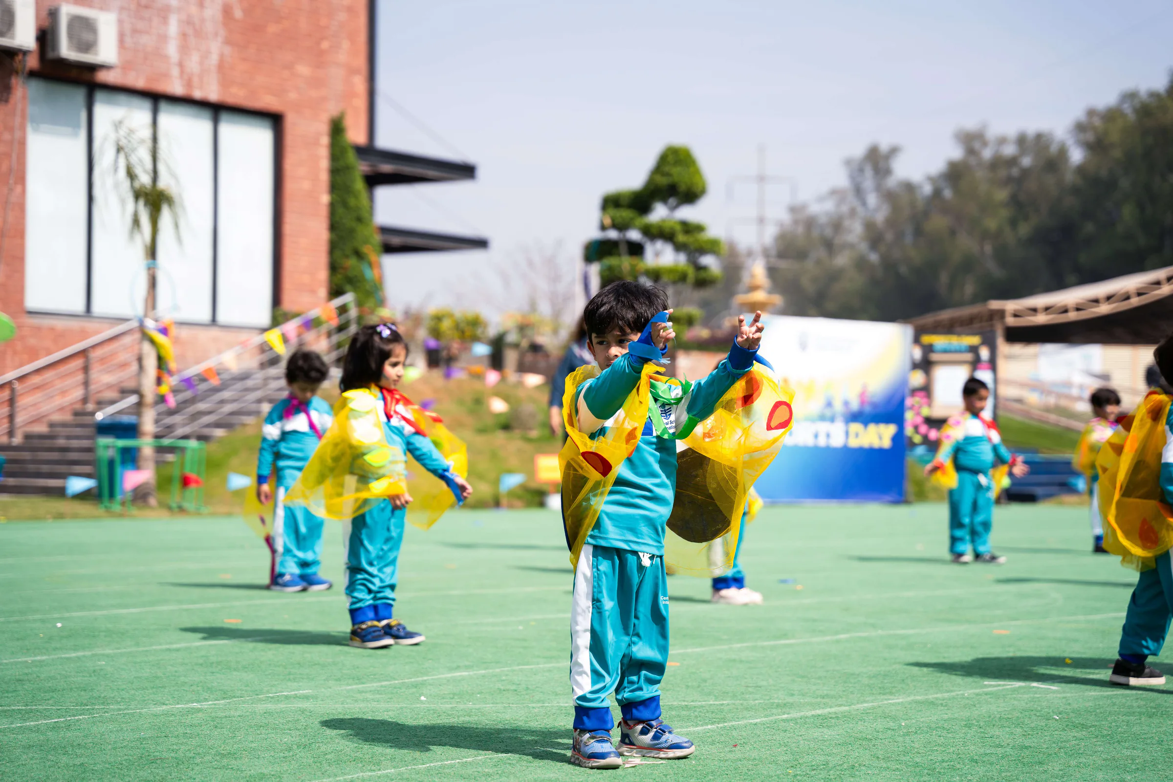 CSI young children moving together on the outdoor campus court.