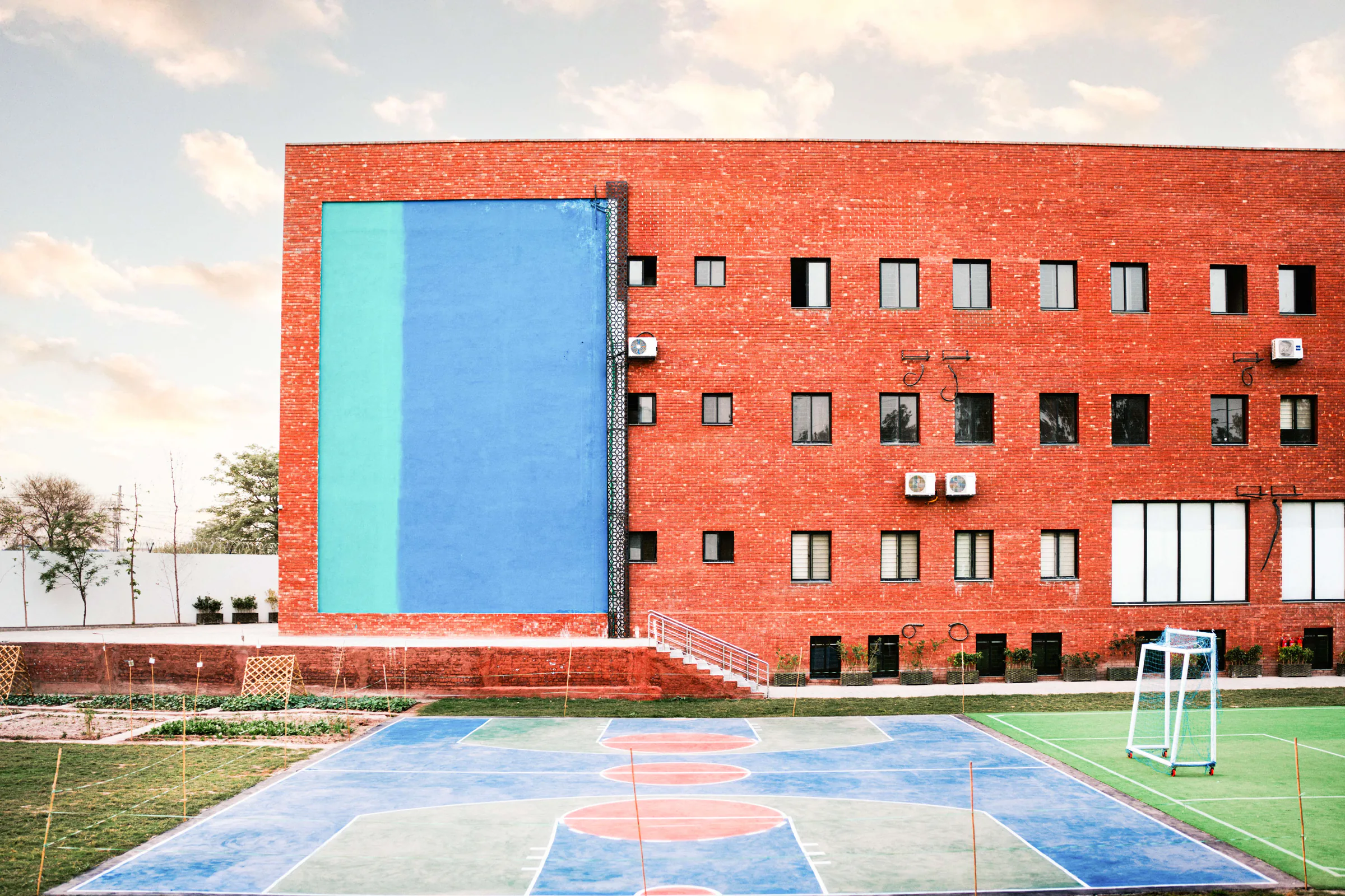 CSI basketball court beside the red-brick campus building.