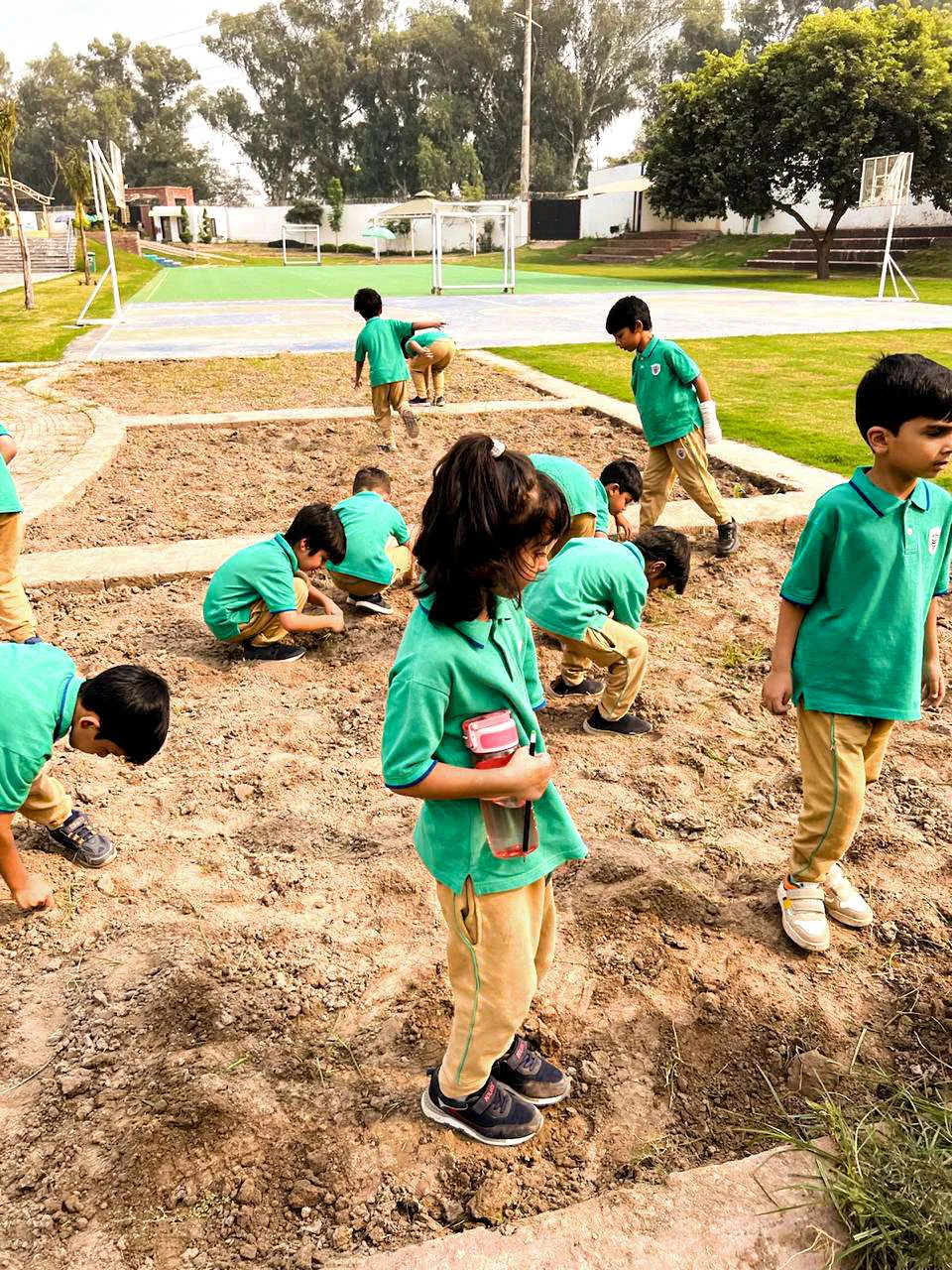 CSI young children exploring the campus garden together.