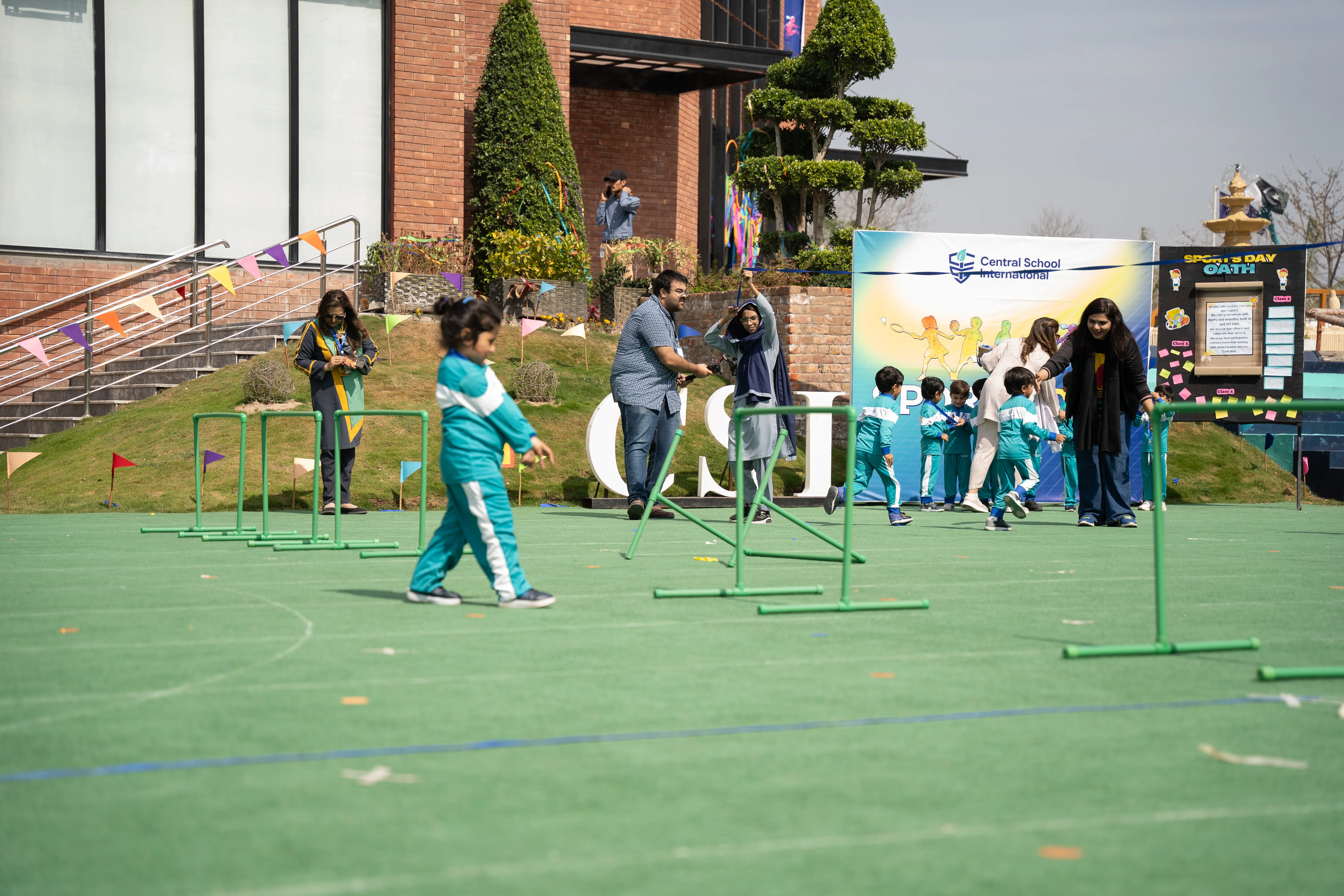 A CSI teacher helping young children during an outdoor activity.